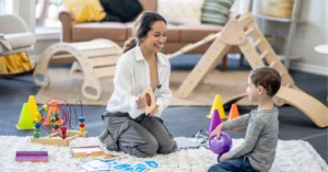 Parent engaging in filial therapy session with child using play therapy techniques showing parents become the therapist approach