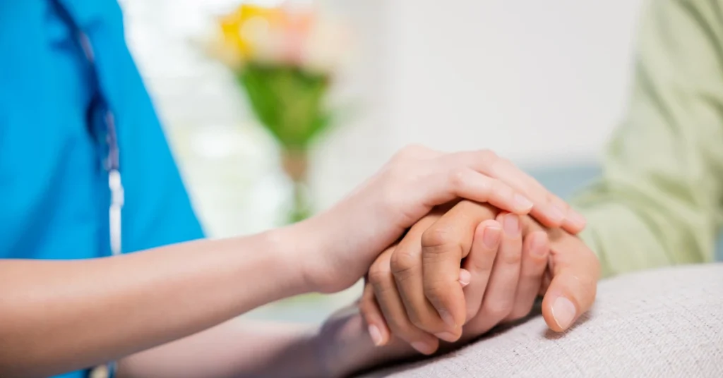 Close-up of a healthcare provider gently holding a patient’s hand, offering comfort and emotional support in a caring environment